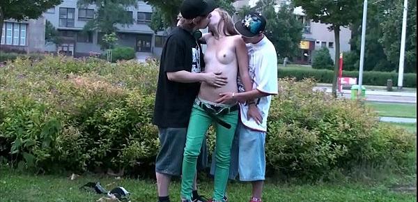  A young pretty teen blonde girl is fucked in public by 2 guys on the street with a blowjob sucking dicks and vaginal pussy sex penetration with all the cars and trucks passing by watching the risky orgy